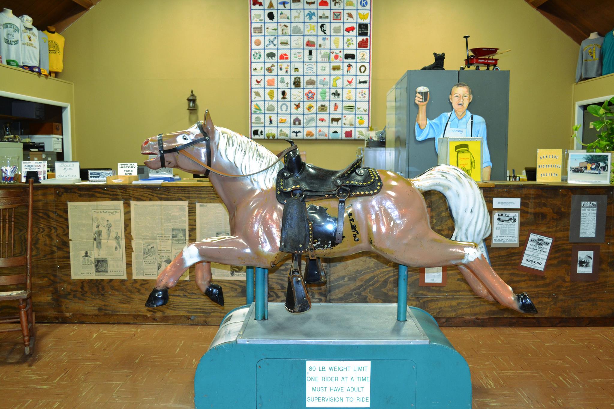 A vintage Sandy mechanical horse ride in front of a museum counter.
